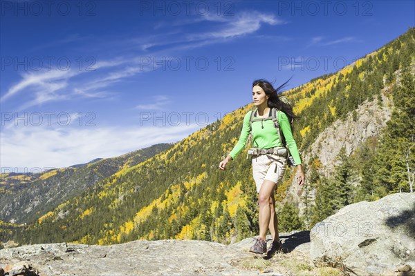 Mixed race woman hiking on rocky hilltop