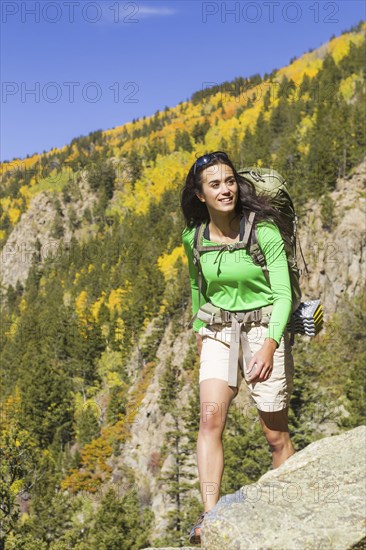 Mixed race woman hiking on rocky hilltop