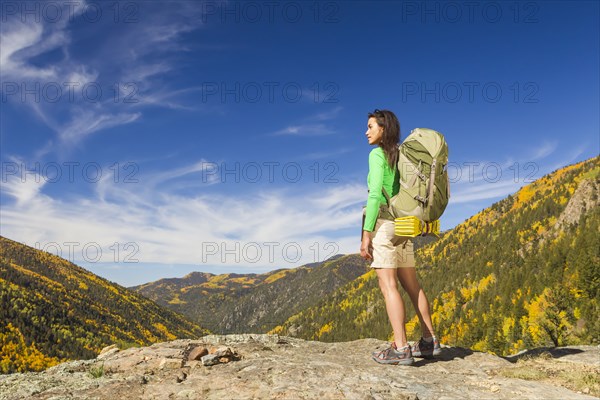 Mixed race woman standing on rocky hilltop