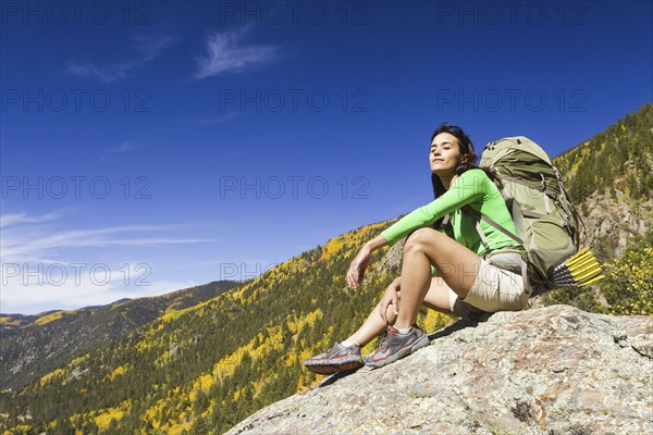 Mixed race woman sitting on rock