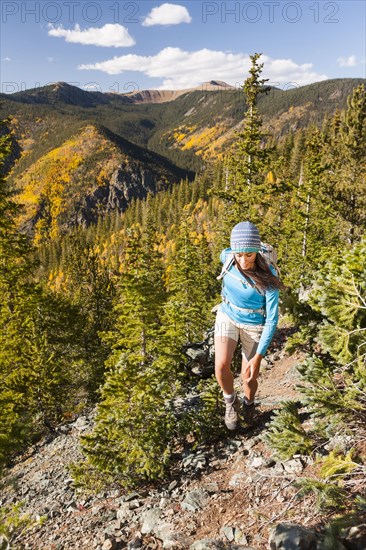 Mixed race woman hiking on rocky hillside