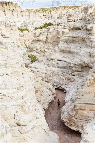 Woman running in canyon wearing backpack