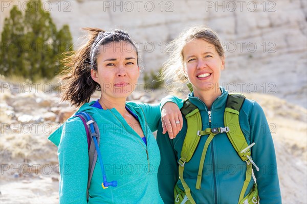 Confident women standing in canyon wearing backpacks