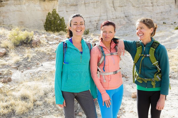 Confident women standing in canyon wearing backpacks