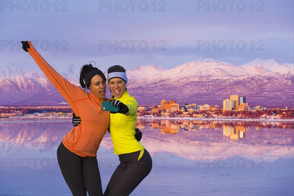 Women posing for cell phone selfie near mountain river