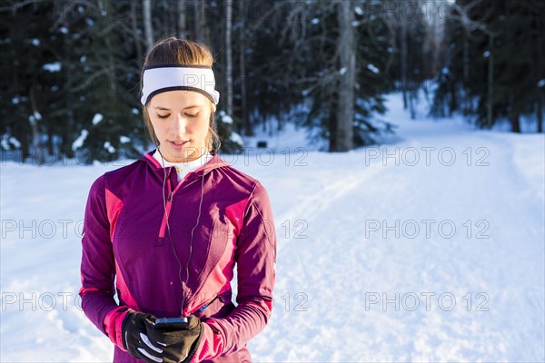 Caucasian woman listening to cell phone with earbuds