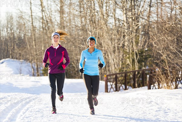 Women running on snow in winter