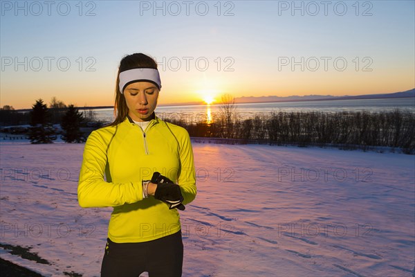 Caucasian woman checking the time on wristwatch in winter