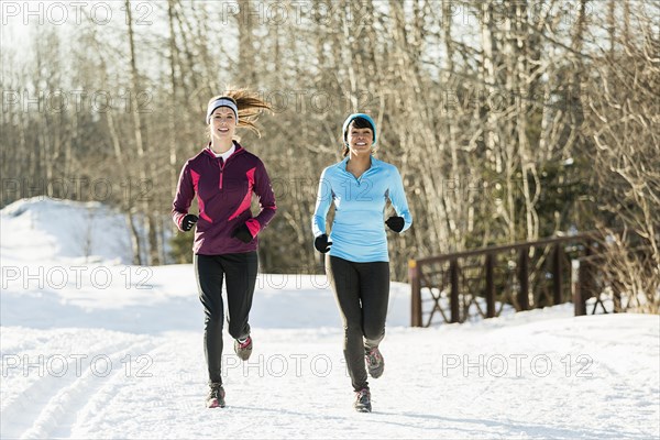 Women running on snow in winter