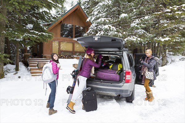 Friends unloading car at winter resort