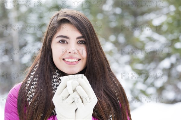 Mixed Race woman holding warm beverage outdoors in winter