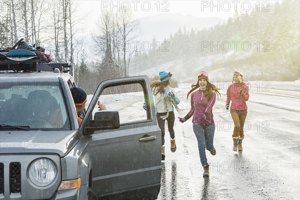 Women running to car in winter