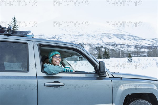 Caucasian woman  leaning in car window in winter