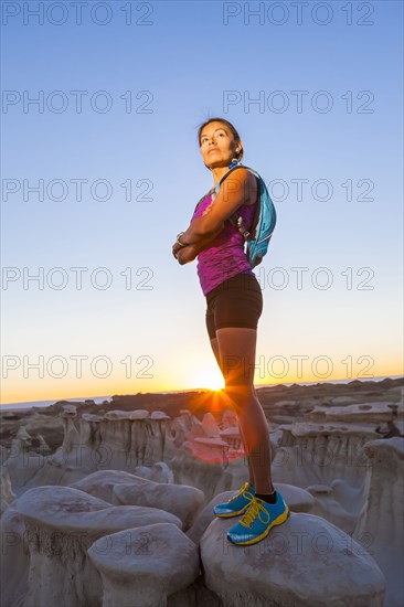 Native American woman standing on rock in desert