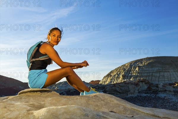 Native American woman sitting on rock in desert