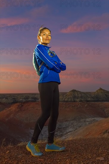 Native American woman standing in desert at sunset