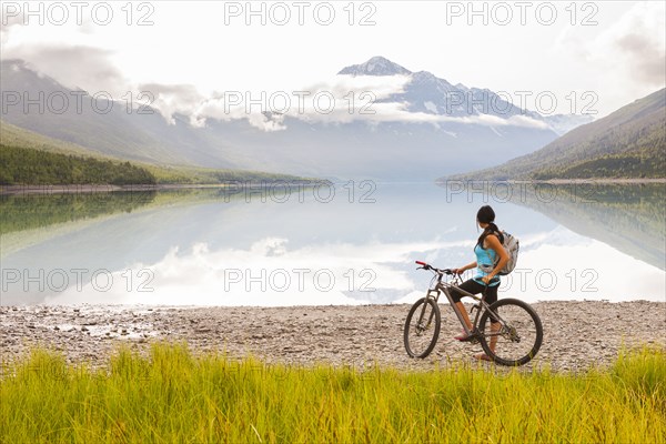 Mixed Race woman riding a bicycle near lake