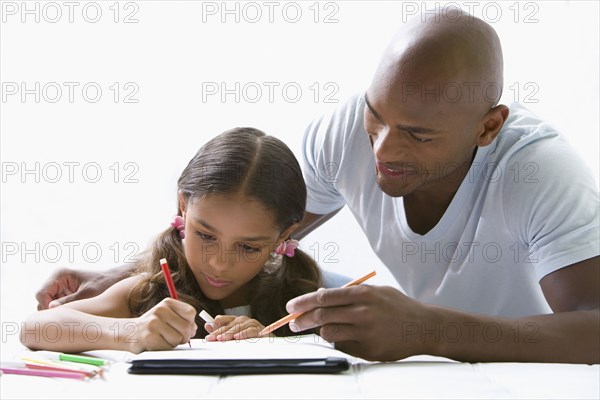 Mixed race father helping daughter with homework