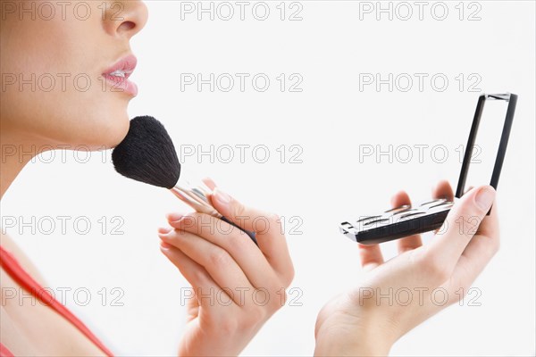 Mixed race woman applying makeup