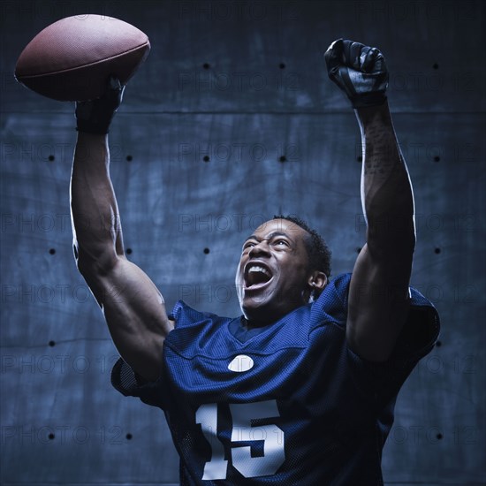 African football player cheering with arms raised