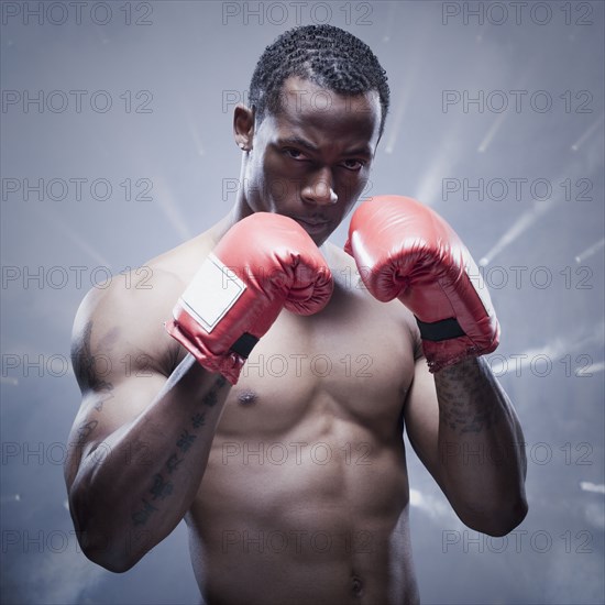 Back lit African boxer with arms raised