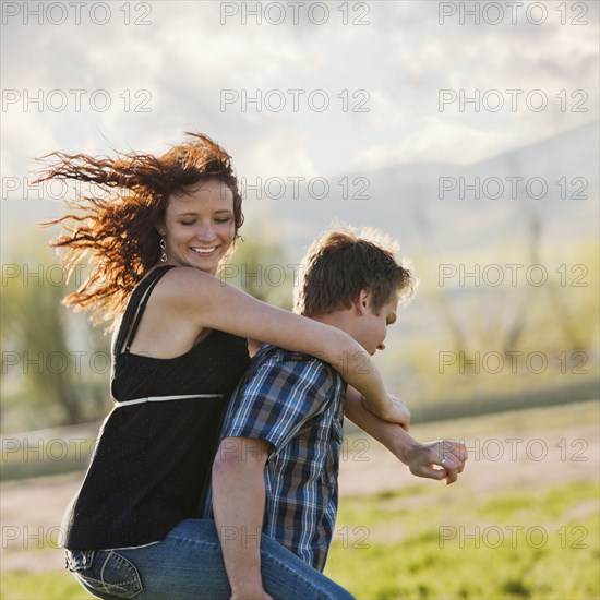 Caucasian man giving girlfriend piggyback ride