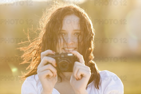 Caucasian woman taking photograph with camera