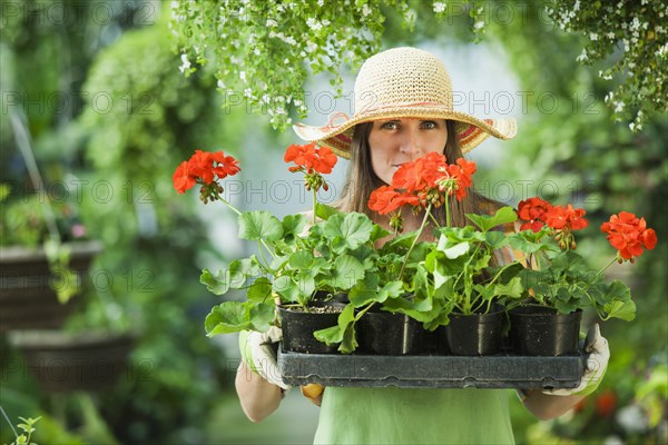 Caucasian woman carrying tray of flowers