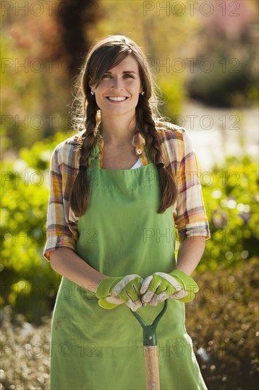 Caucasian woman standing with shovel in plant nursery