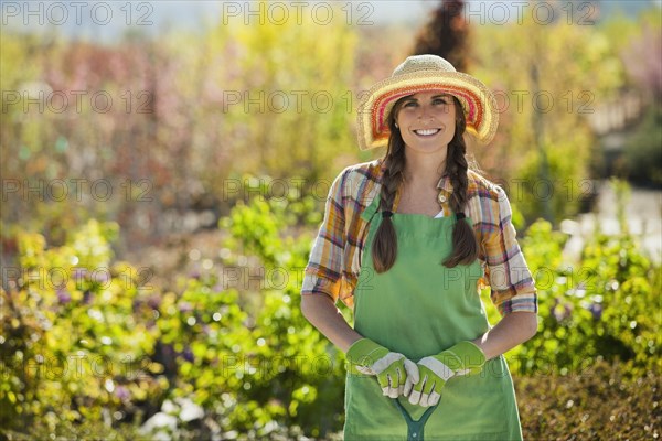 Caucasian woman standing with shovel in plant nursery