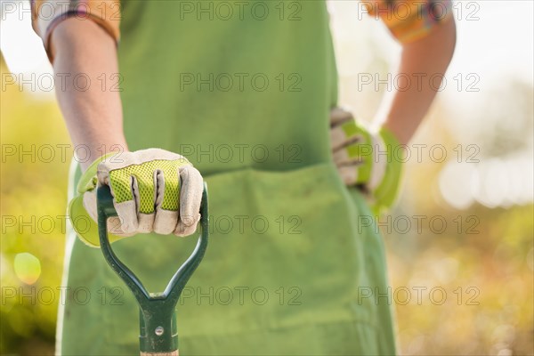 Caucasian woman standing with shovel in plant nursery