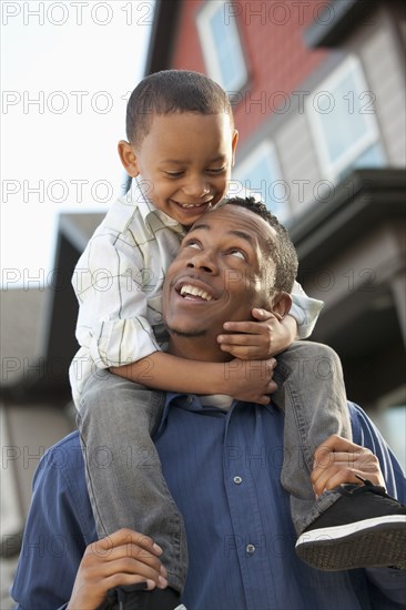 Father carrying son on shoulders