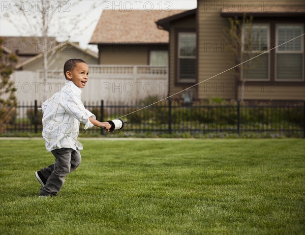 Mixed race boy flying kite