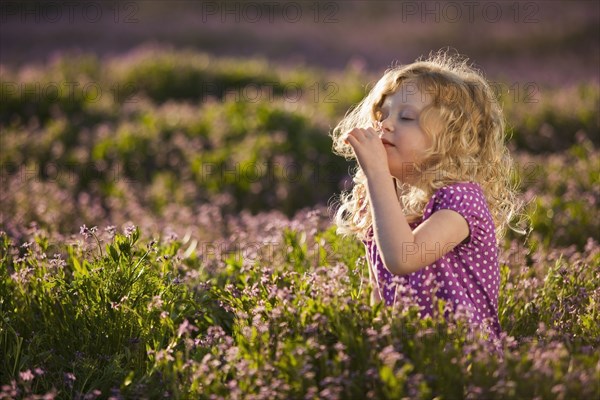 Caucasian girl smelling flowers