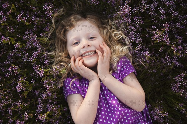 Caucasian girl laying in flowers