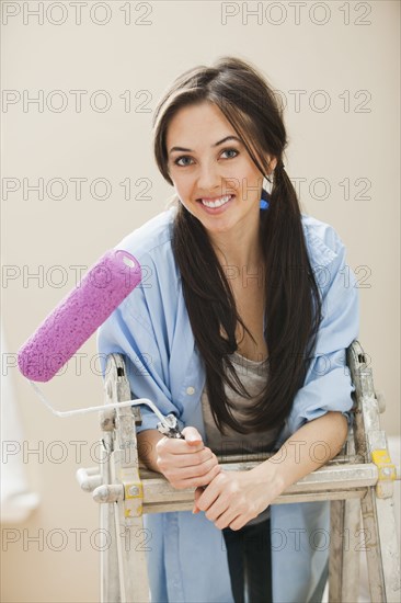 Caucasian woman holding paint roller