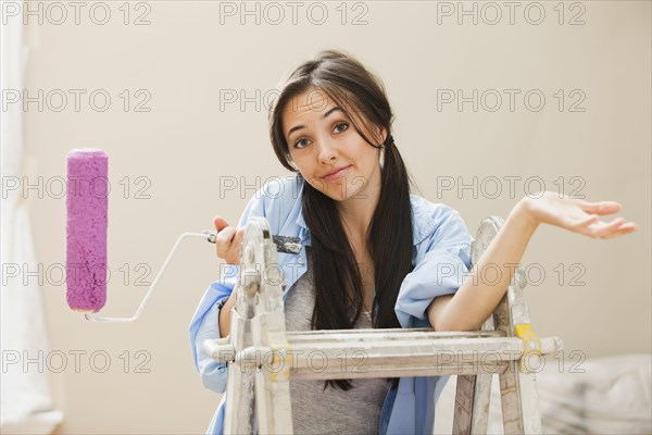 Caucasian woman holding paint roller