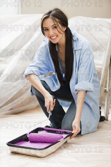 Caucasian woman using paint roller