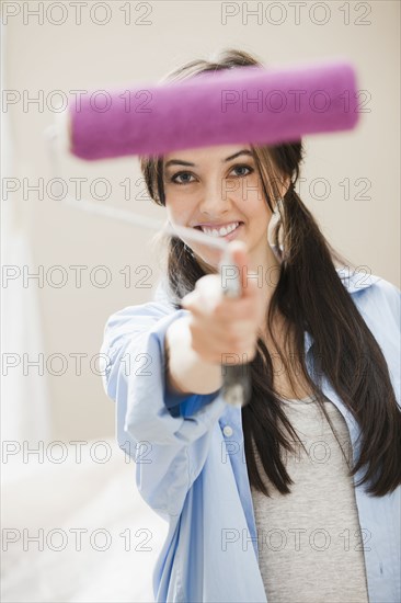 Caucasian woman holding paint roller