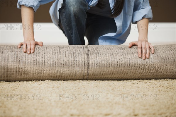 Caucasian woman unrolling carpet