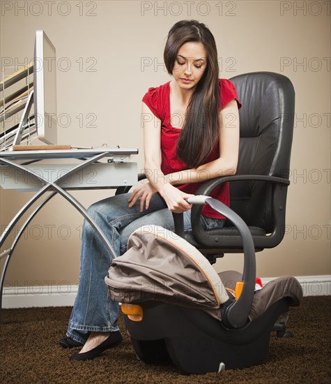 Caucasian woman sitting at home office looking at baby