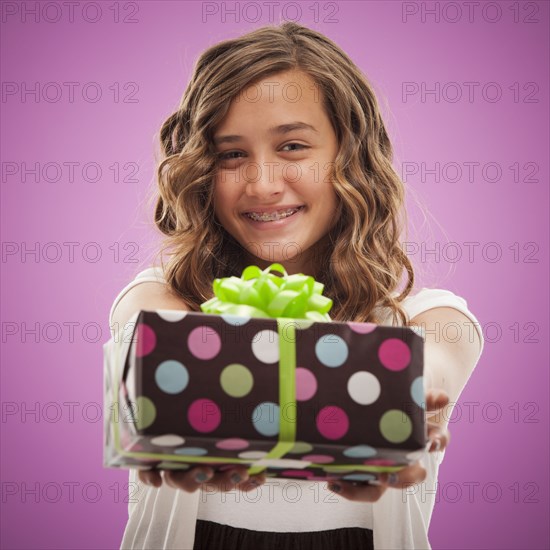 Caucasian teenager holding out gift