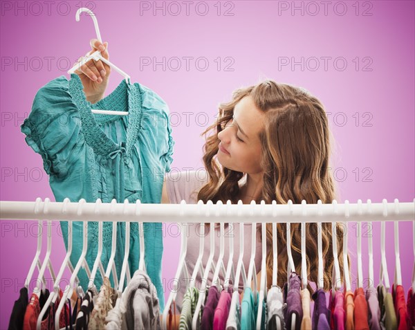 Caucasian teenager looking at shirt