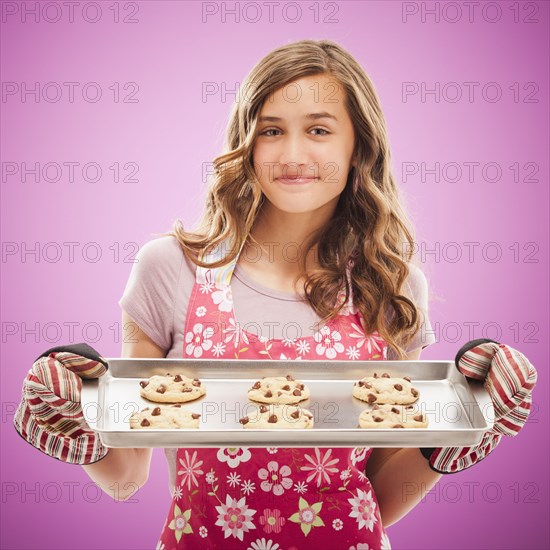 Caucasian teenager holding tray of fresh cookies