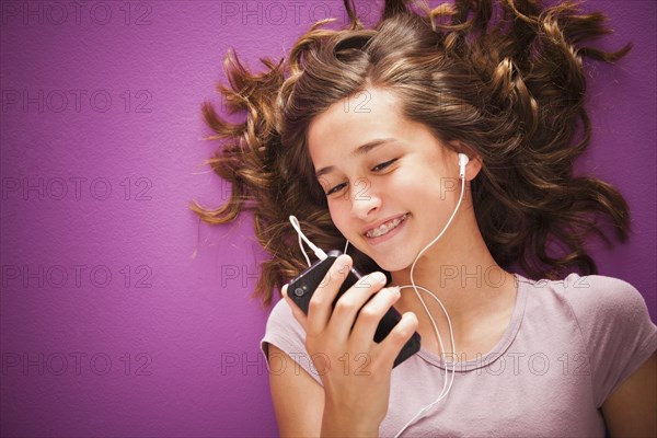 Caucasian teenager listening to music on mp3 player