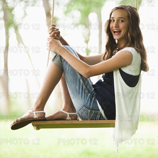 Caucasian girl sitting on swing