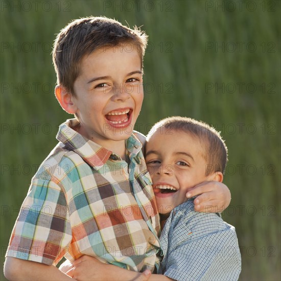 Caucasian brothers hugging