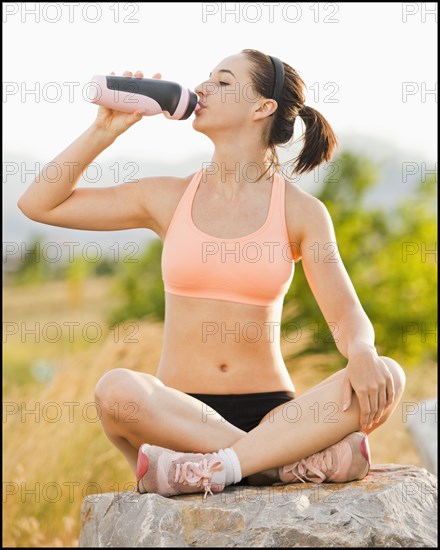 Caucasian woman drinking water after workout