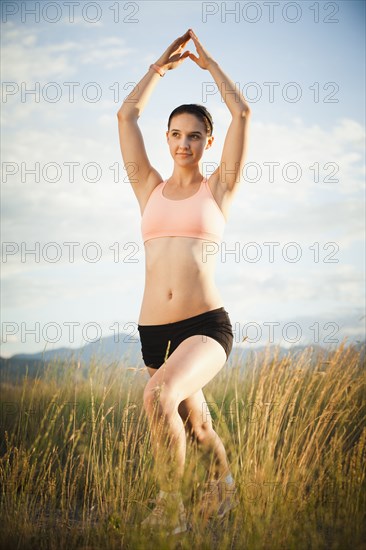 Caucasian woman exercising in field