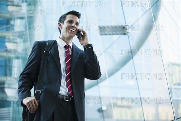 Caucasian businessman talking on cell phone outdoors